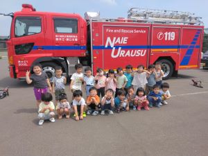 消防車の横で整列している園児